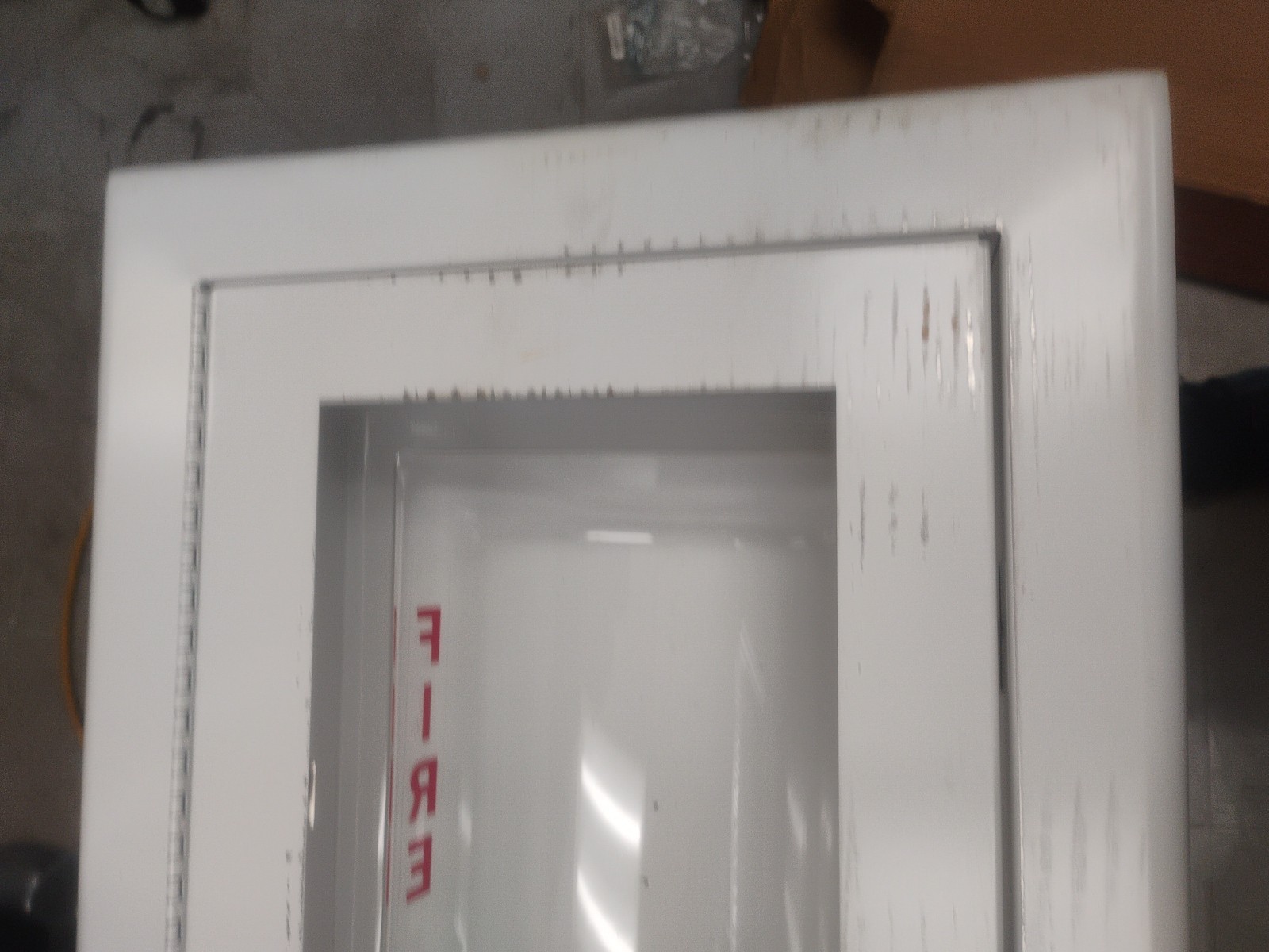 white fire extinguisher cabinet with a breakable glass panel