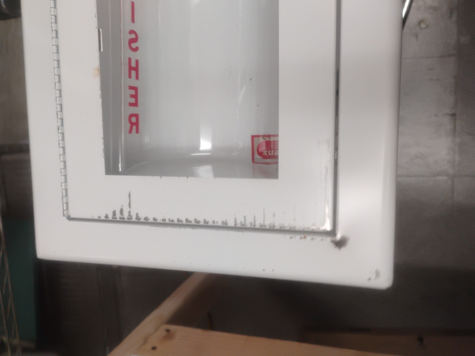 white fire extinguisher cabinet with a breakable glass panel